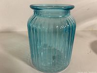 Front view of turquoise ribbed glass holder showing cylindrical shape and vertical ribs
