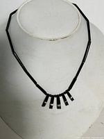 Full view of black coral bib necklace on bust