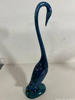 Front view of tall blue-green glazed swan figurine