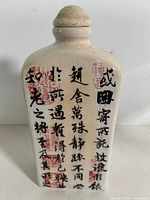 Front view of cream ceramic bottle showing calligraphy