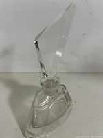 Front view of clear cut crystal perfume bottle showing geometric body and stopper