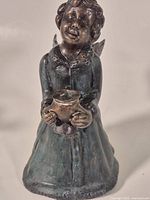 Front view of bronze angel figurine holding cup