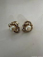 Pair of gold tone knot studs with faux pearl centers
