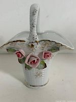 Front view of porcelain basket showing roses and handle