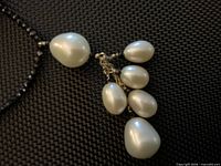 Close-up of white pearl cluster pendant with gold links