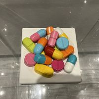 Top view of multicolour pill sculpture on white base