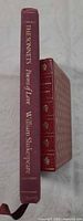 Spines of both hardcover editions showing titles and decorative gilt tooling
