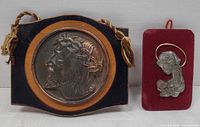 Front view showing both plaques: circular Jesus relief on wood and rectangular Madonna relief on velvet