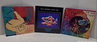Front view of all three record jackets standing side by side