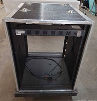 Front of rack case showing PDU, rack rails and cord