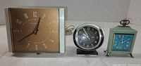 Front view of three clocks side by side