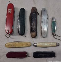 Overview of all nine knives laid out closed