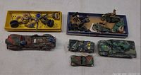 Overview of two trays with loose wheels, propeller, motorcycles and four vehicles
