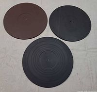 Front view of brown, black textured, and black smooth sides showing three mats