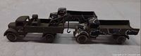 Side view of both tow truck models displaying overall form and paint wear
