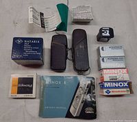 Group shot of entire lot including camera, cases, Natarix accessory and box, film boxes, external viewfinder, battery pack and manuals