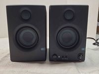 Front view of both monitors showing woofers, tweeters, power/volume controls