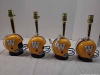 Front and side view of four helmet lamps showing logos, faceguards, sockets and cords