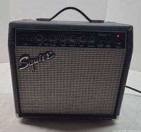 Front view of Squier Champ 15 amplifier powered on