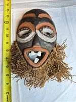 Full view of mask beside tape measure showing ~11 in height