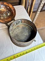 Top view of interior and hanging chains of copper bowl showing patina and rivets