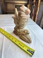 Front angled view showing full figurine and measuring tape for scale