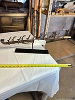 Full view of ceremonial pipe on display stand with measuring tape showing length