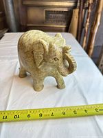 Front left view of carved soapstone elephant showing trunk and facial features