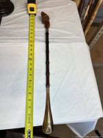 Full cane alongside measuring tape showing length under 24 in