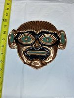 Front view of copper mask showing size against tape measure