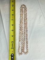 Full view of necklace alongside tape measure showing 18 in length