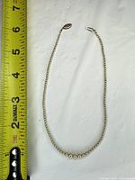 Full necklace beside ruler showing length, bead gradation