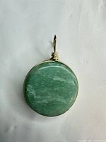 Front view of round green stone pendant