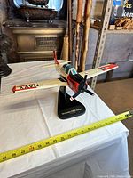 Port front view of model on stand showing livery and measurement tape at wingspan