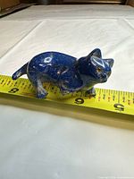Left side view of blue lapis figurine on tape measure