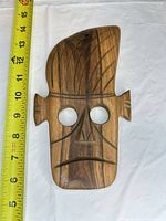 Full front view of wooden Tiki mask with measuring tape showing height