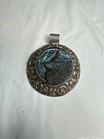 front view of pendant showing carved labradorite wolf and silver border