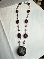 Full view of long necklace showing bead sequence and pendant