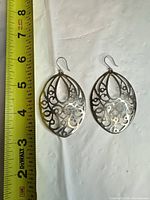 Both sterling silver filigree earrings beside ruler for size reference