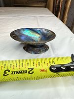 Side view of paua shell dish with measuring tape showing width ~3–4 in.