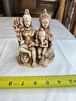Front view of resin statue with measuring tape showing scale