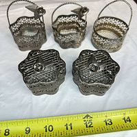 Front view showing three baskets and three lidded boxes with ruler for scale