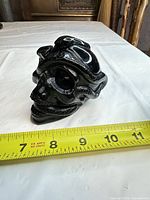 Front angled view showing skull and snake details with tape measure indicating size