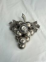 Front view of sterling silver grape cluster brooch