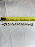 Bracelet laid straight beside tape measure showing length ~7.5 inches