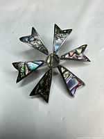 Front of sterling silver brooch showing abalone inlay and starburst shape