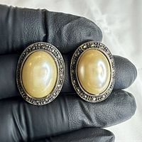 front view of both oval earrings showing ivory cabochons and marcasite border