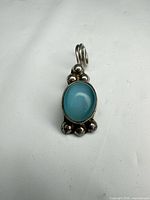 Front view of sterling silver pendant with blue cabochon