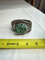 Front view showing large turquoise stone on cuff with measuring tape for scale