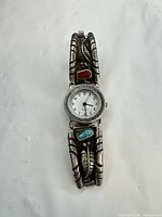Full view of watch front showing dial and decorative sterling silver tips with turquoise and coral